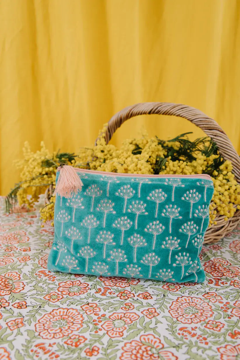 Medium Size pouch in velvet type material in a teal blue with sliver patterned flowers embroidered on the front. There is a pale pink zip with a pale pink tassel.