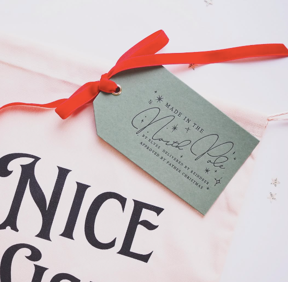 set of 3 christmas gift tags each has Made in the north pole written on one side. the base colour is dark grey and the writing is in black