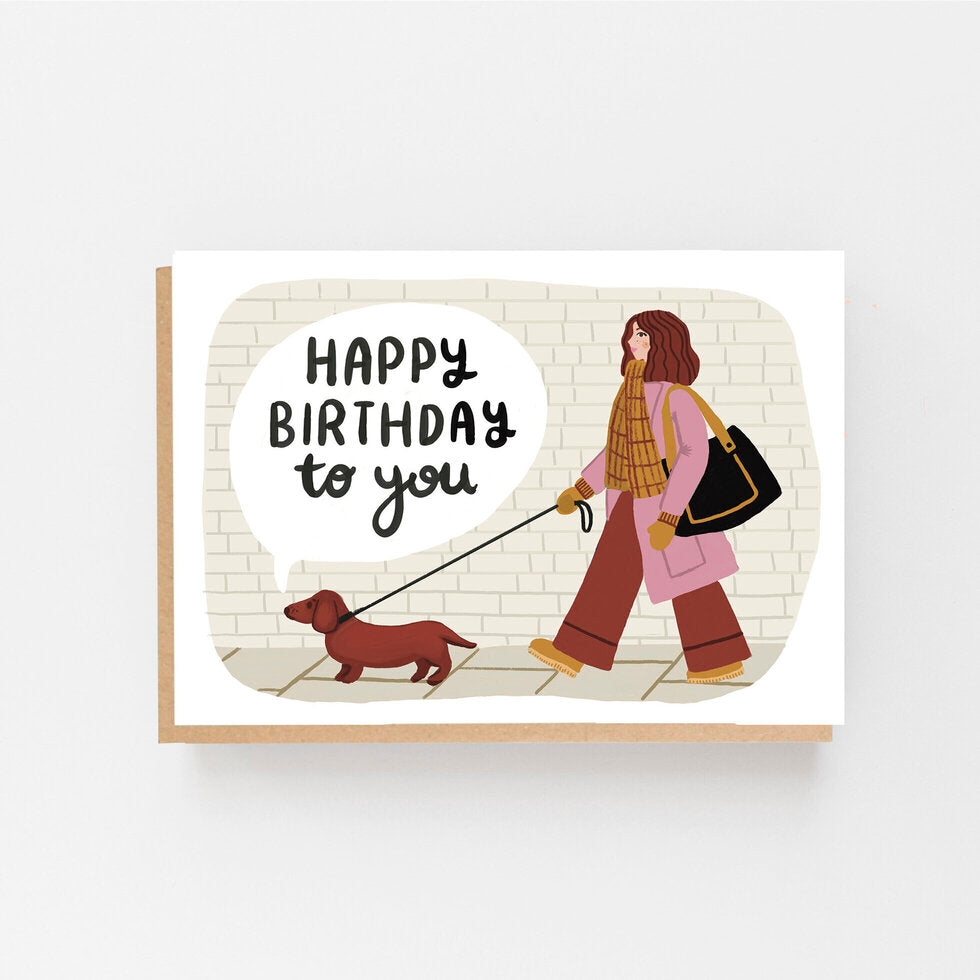 Happy Birthday to you are written on the front along with a picture of a lady walking a dachshund.