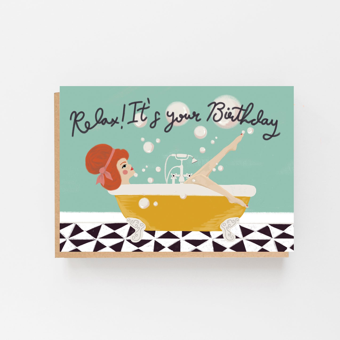 Greeting Card in landscape with a pale blue background with the words Relax ! It's Your birthday in black. There s a picture of a lady in a bath with white bubbles above the bath which is yellow in colour and a black and white tiles below the bath. Brow Kraft Envelope.