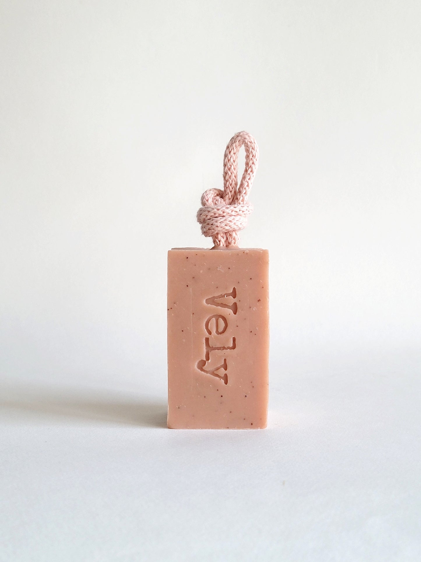Pink soap with pink rope. the fragrance is amelie. The word Vely is etched into the soap bar