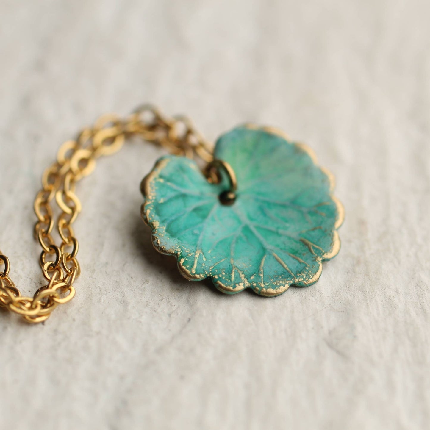close up image of the turquoise leaf necklace with gold chain