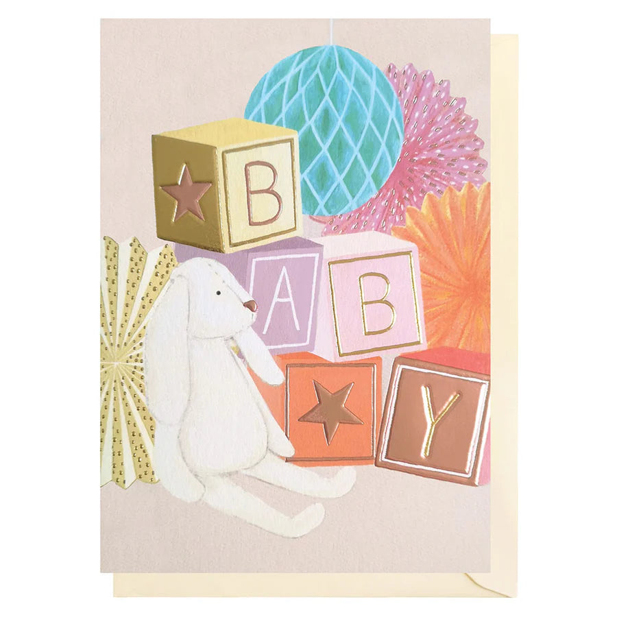 Baby-themed greeting card with rabbit, blocks, and decorative elements on a beige background