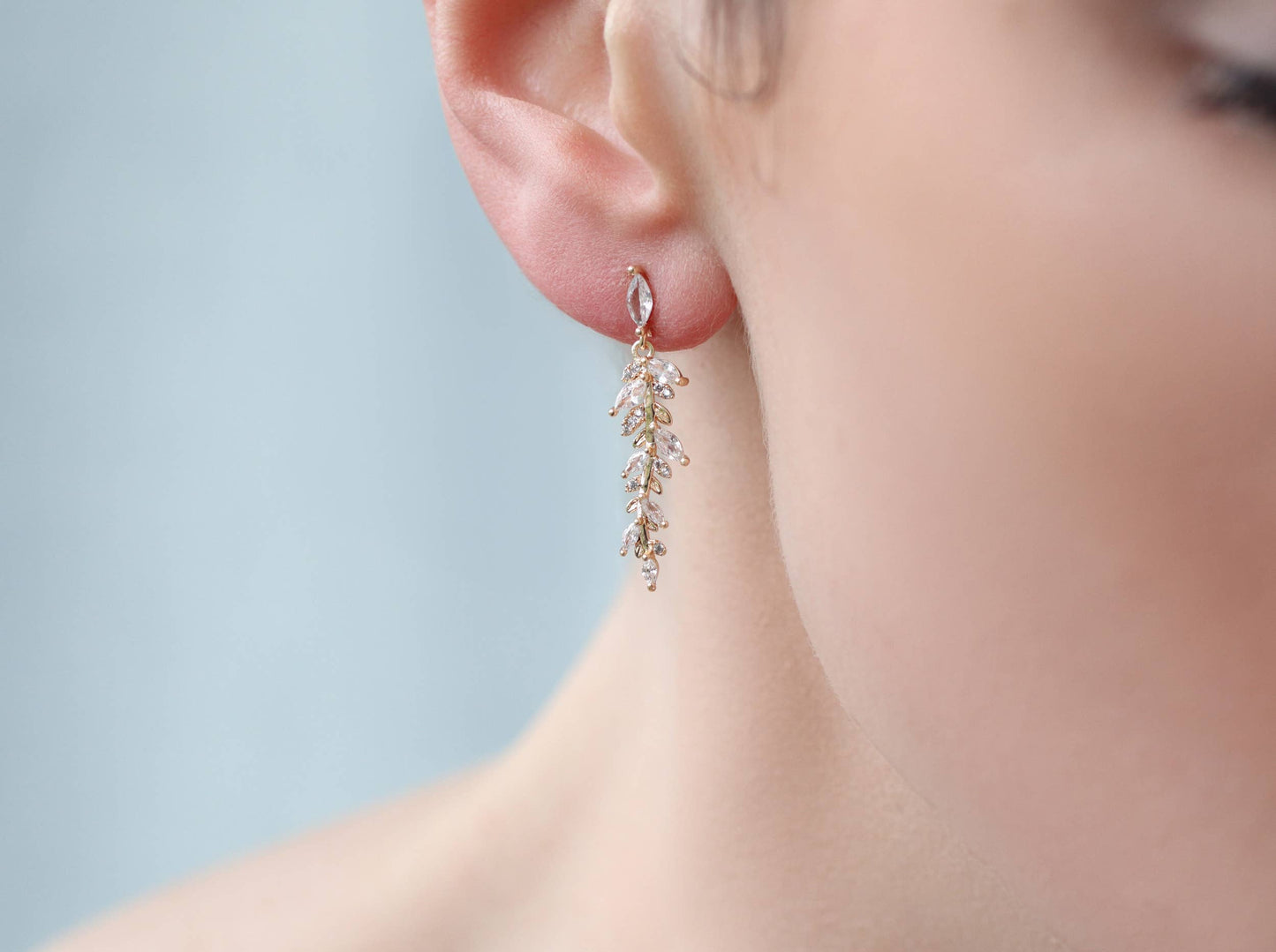 image of one the long drop crystal leaf earrings being worn in a ladies ear