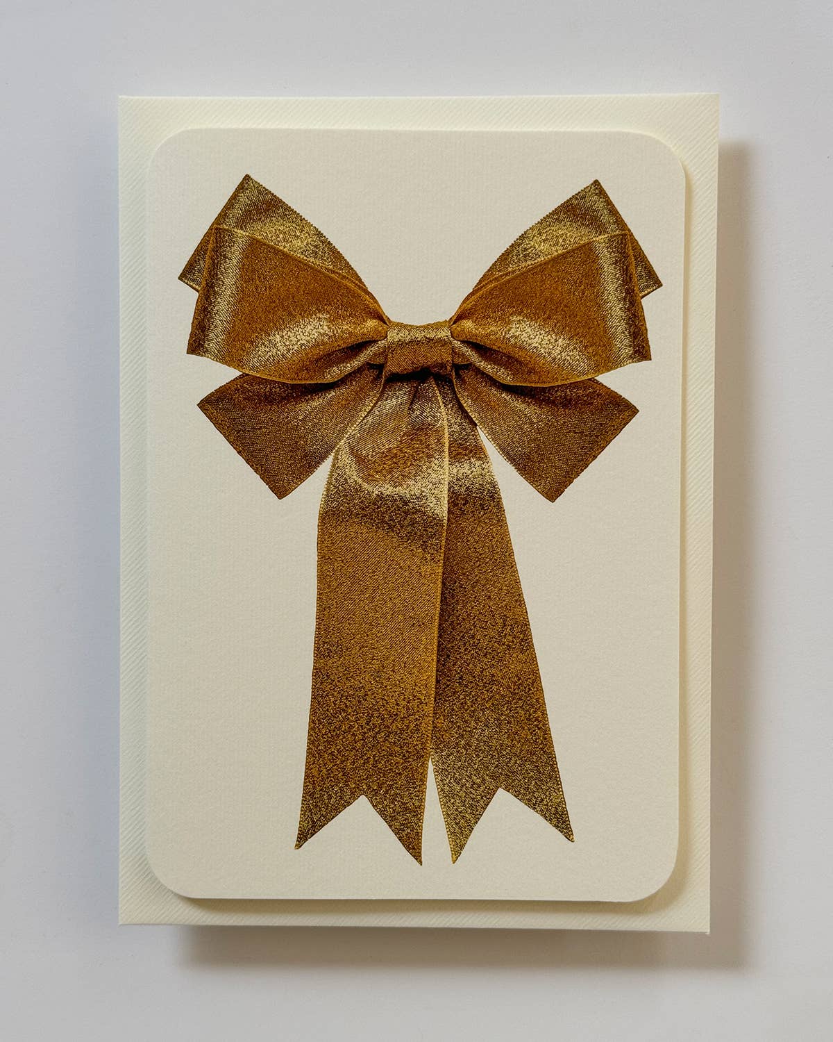 Greetings Card with a Gold Ribbon looking bow on the front. Looks like real material but it is an image White Background. White Envelope.