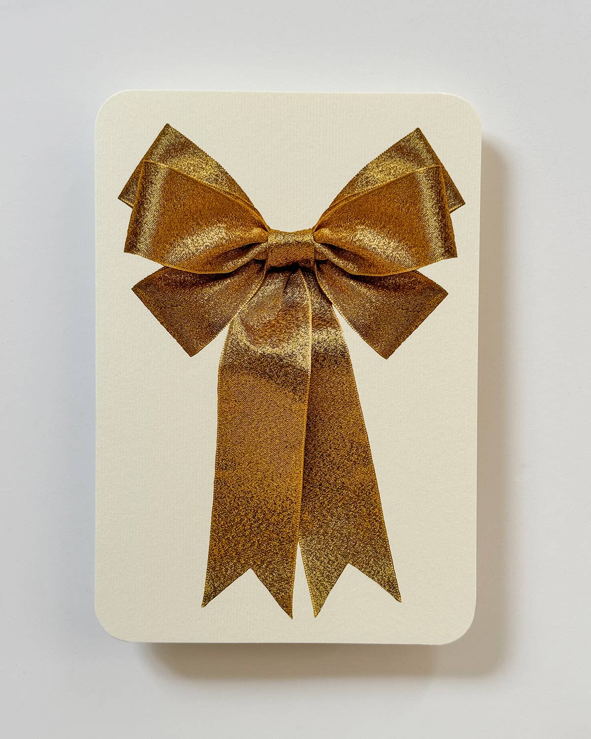 Greetings Card with a Gold Ribbon looking bow on the front. Looks like real material but it is an image White Background. White Envelope.