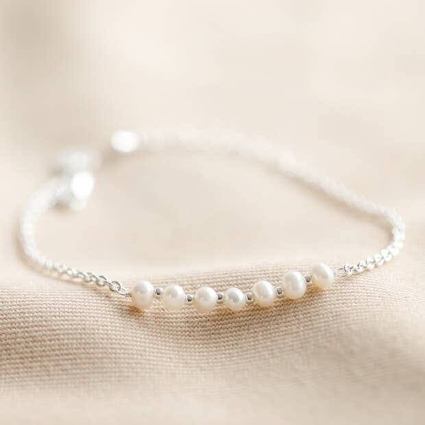 Pearl bracelet on a beige fabric background