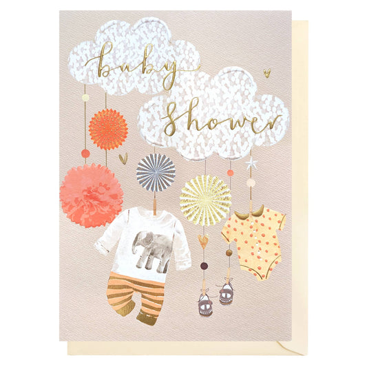 Baby shower card with baby clothes and decorations on a beige background