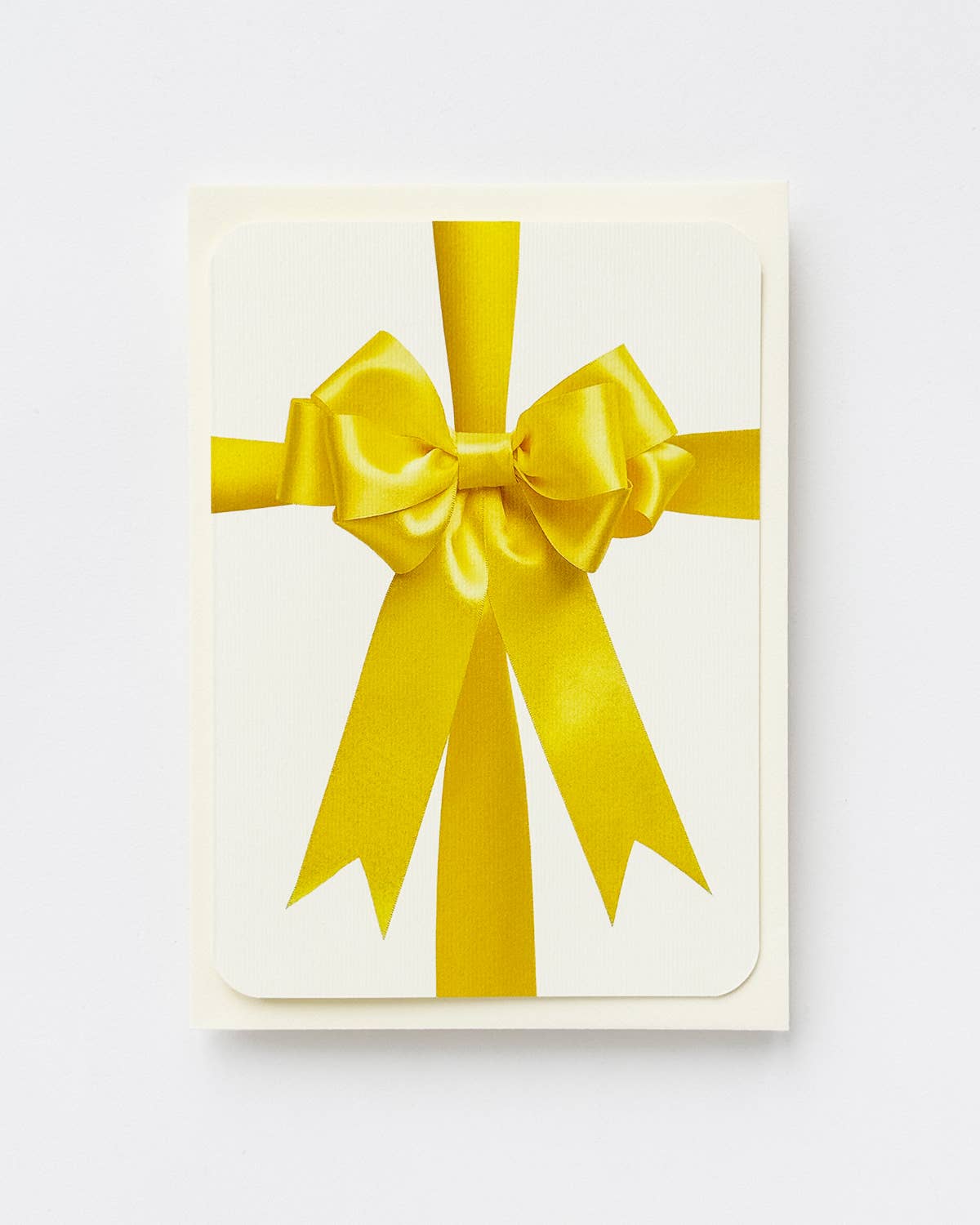 Greetings Card with a Bright Yellow Ribbon looking bow on the front. Looks like real material but it is an image  White Background.  White Envelope.
