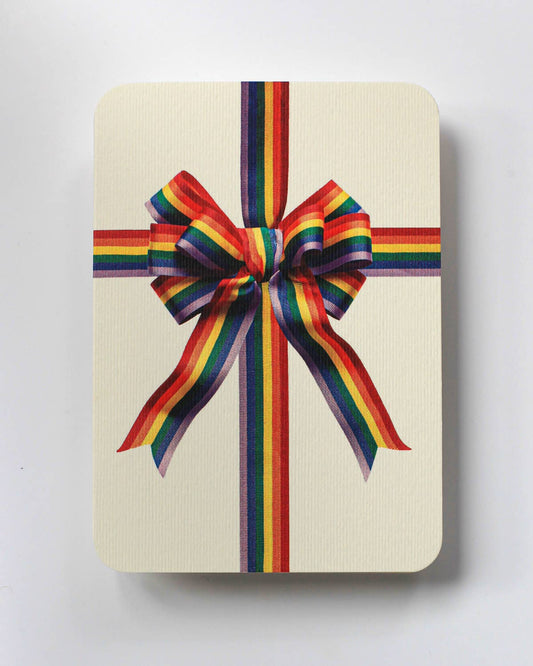 Greetings Card with a Multicoloured Ribbon looking bow on the front. In Pride colours purple blue green yellow orange and red. Looks like real material but it is an image  White Background.  White Envelope