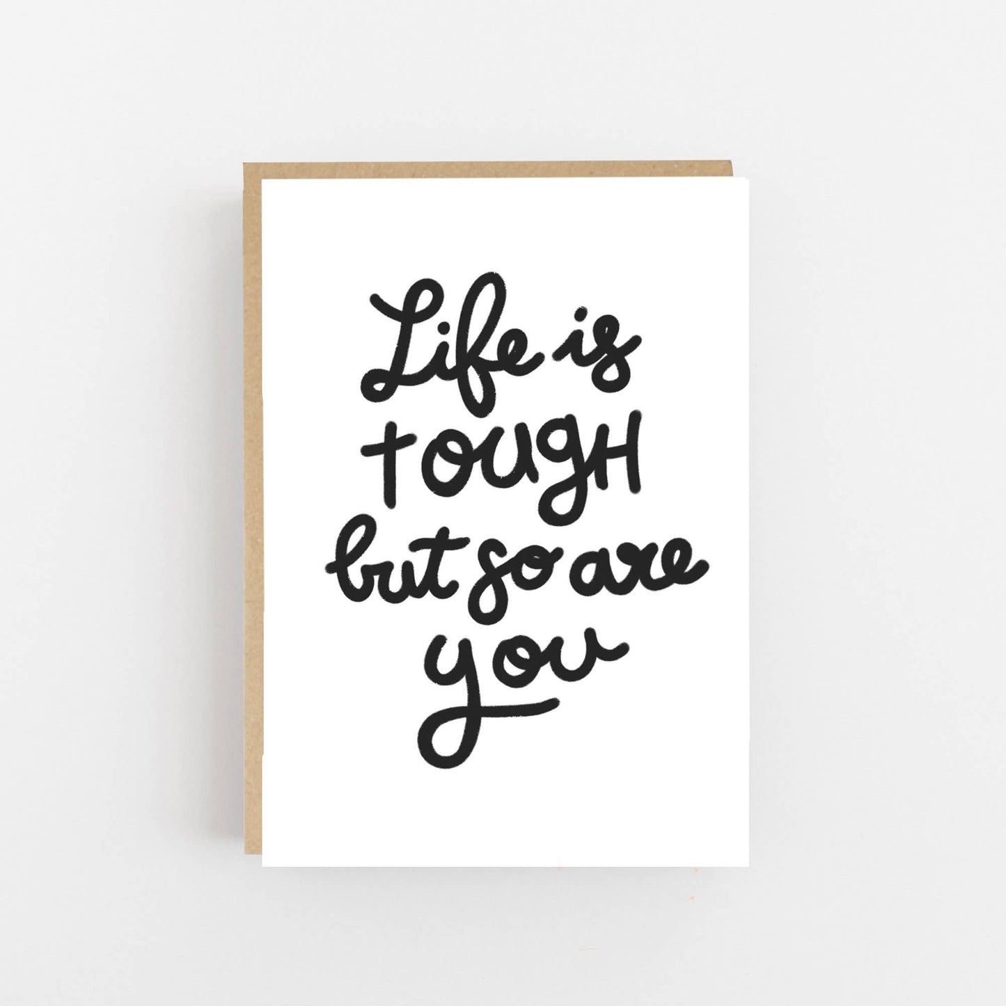 Greeting card with the wording Life is tough but so are you written on the front in  black.  The card is blank inside for your own message and comes with a Kraft envelope.