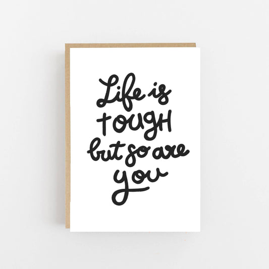 Greeting card with the wording Life is tough but so are you written on the front in  black.  The card is blank inside for your own message and comes with a Kraft envelope.
