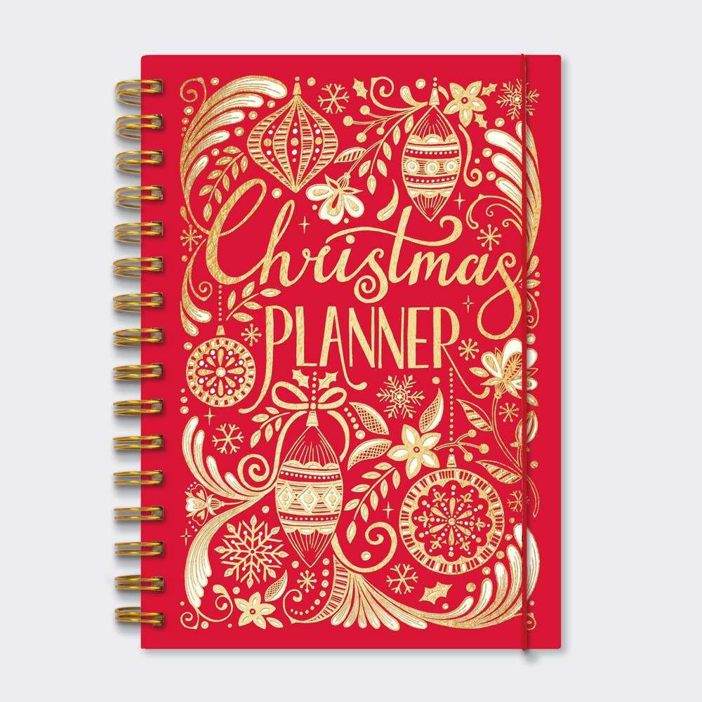 Gold spiral bound red book with gold decorations on the cover and written in gold it states Christmas Planner . There is a piece of red elastic around the right handside of the book.