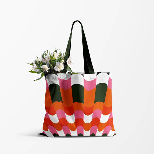 image of a  tote bag with black handles. the body of the bag has a unique retro design using  pink, orange,red and black 