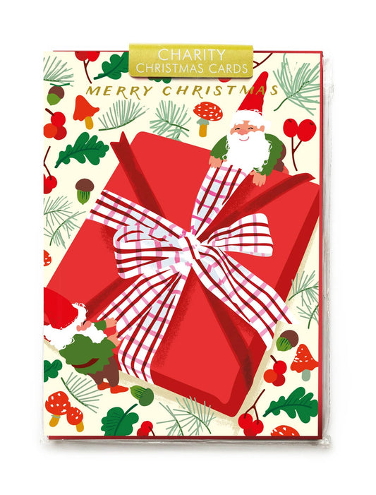 Christmas card with a large red gift box, Santa Claus, and festive illustrations on a white background.