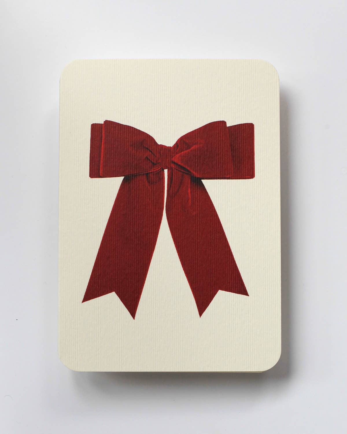 Greetings Card with a Red Velvet looking bow on the front. White Background.    White Envelope.