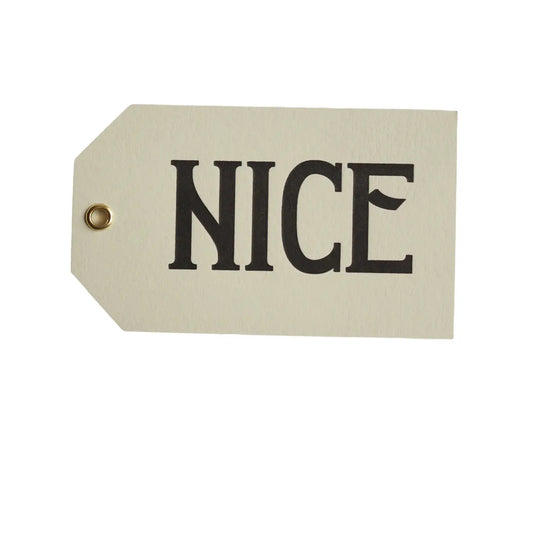 set of 3 christmas gift tags with the word NICE written on one side of the tag in black capital letters. The background colour is pale grey. 