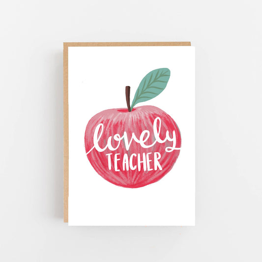 Greeting card featuring a hand drawn red apple on the front with the words lovely teacher written in white in the centre of the apple. The card is blank inside for your own message and comes with a kraft envelope.
