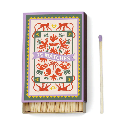 image shows a large box of matches with  purple tips. the front cover of the box is hand-drawn image of long tail red monkeys, red flower with green leaves. 75 matches is written across the front