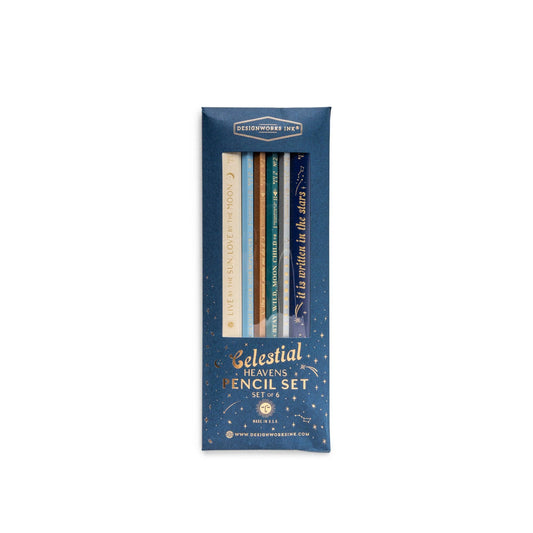 image shows the front of the packaging for the 6 pencil set. This is navy blue card with a perspex window showing the designs of the pencils inside. the words celestial heavens pencil set  set of 6 are embossed on the bottom portion oft the packaging