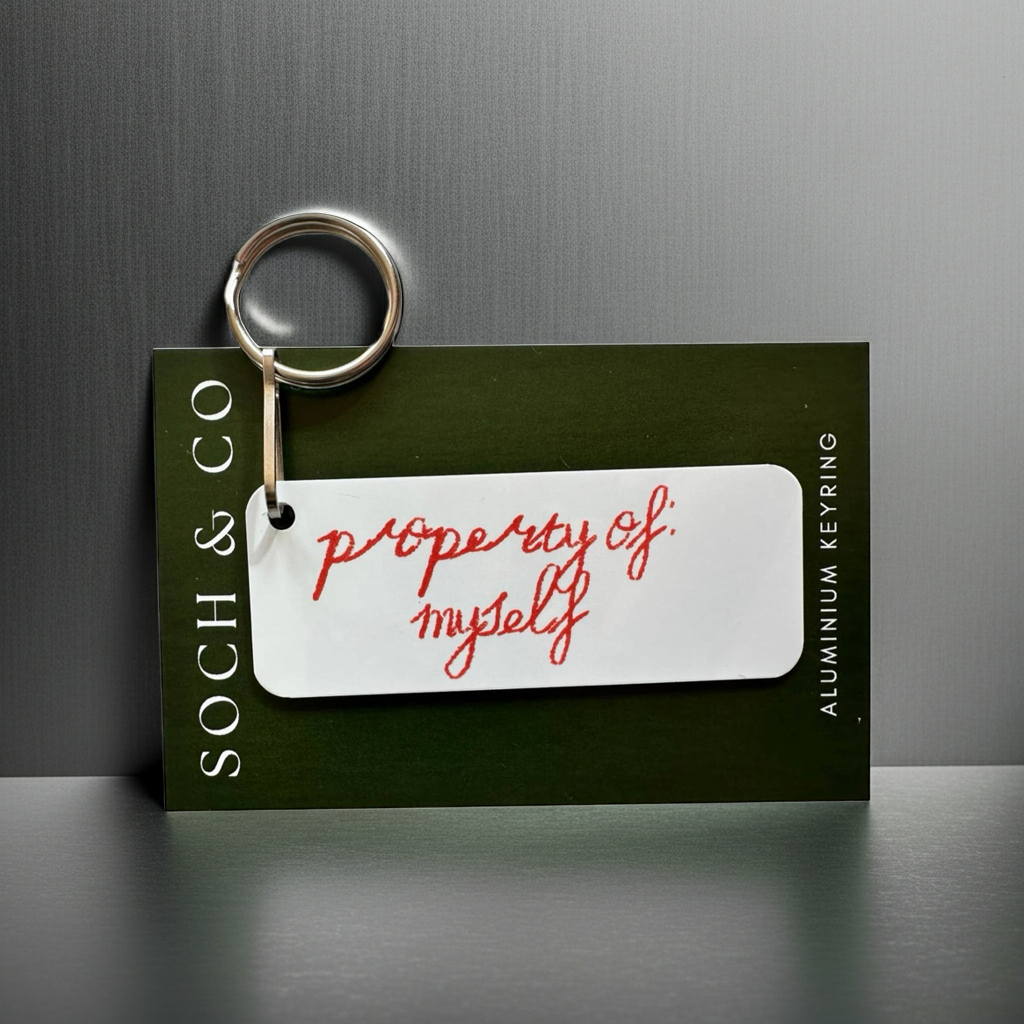 Keychain with 'property of myself' tag on a dark background