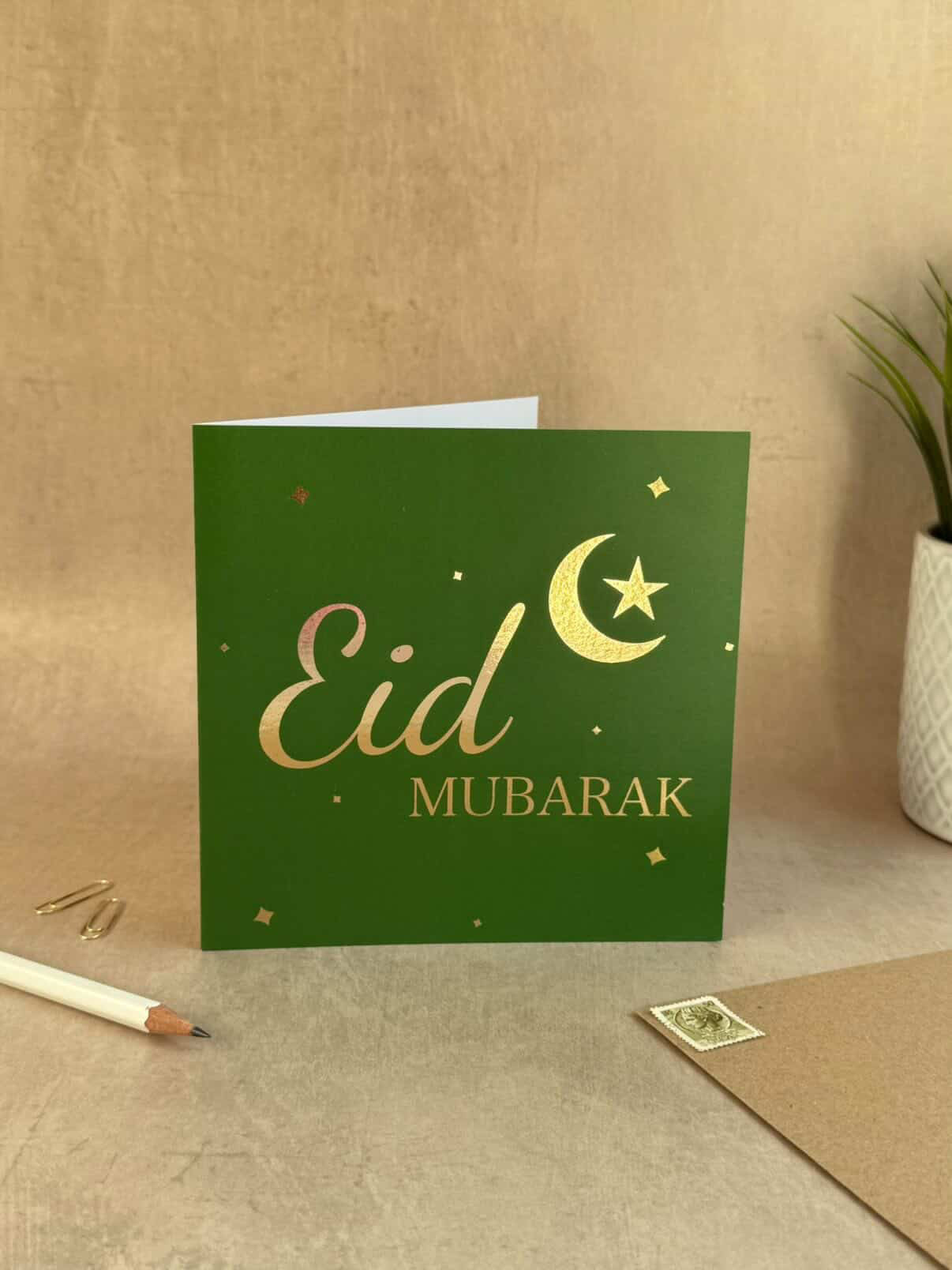 Green card with 'Eid Mubarak' text on a wooden surface