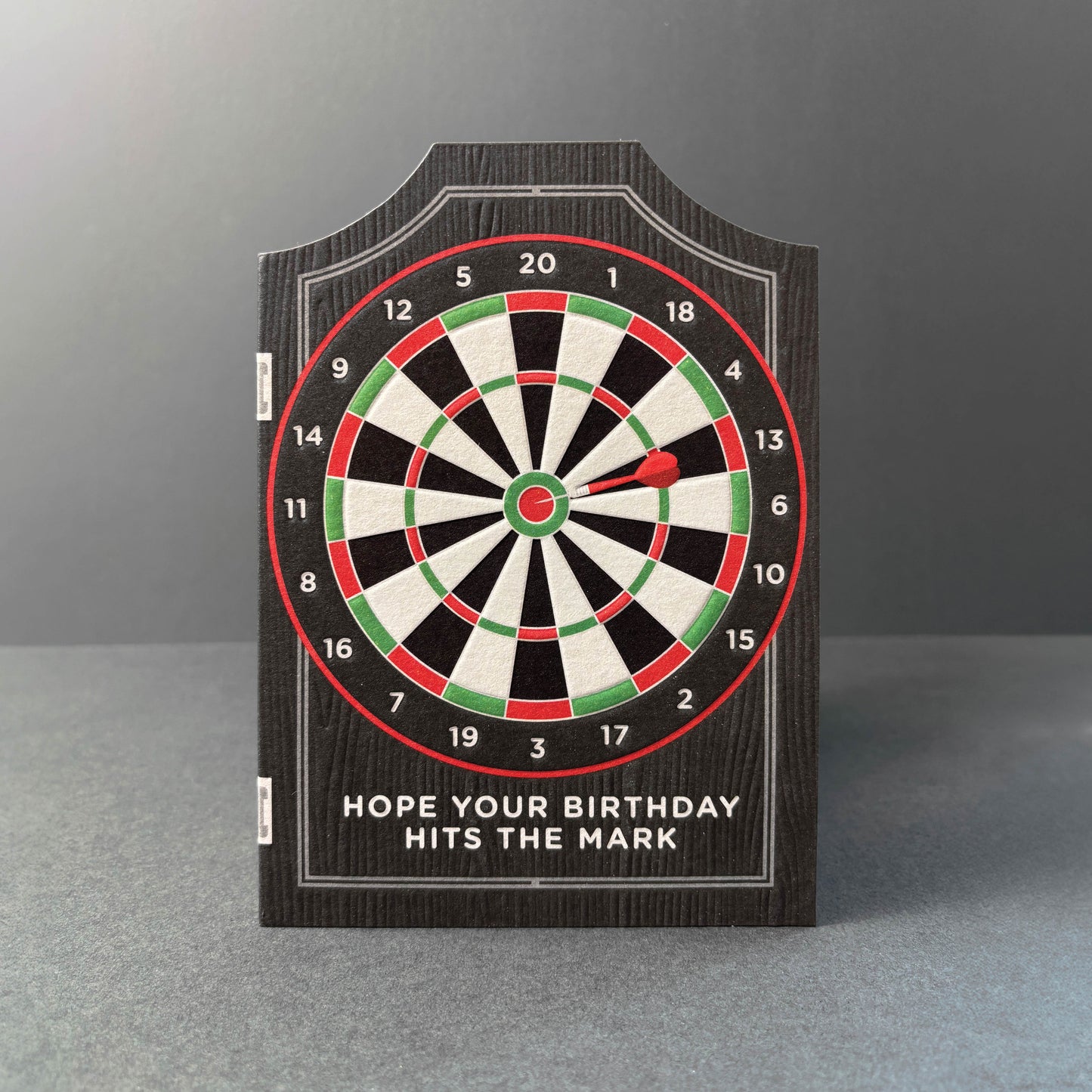 Dartboard with a birthday message on a gray background