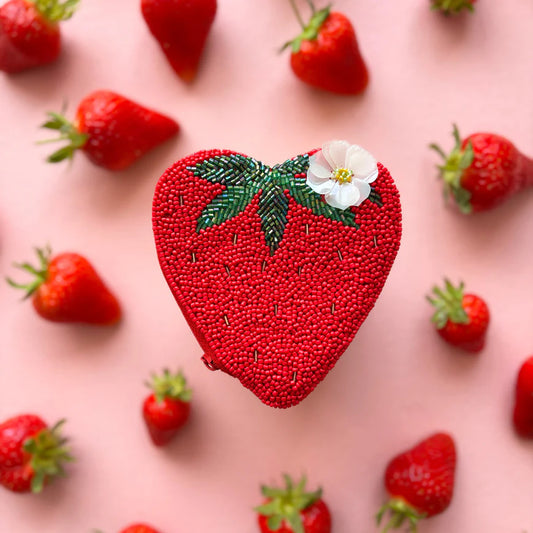Heart-shaped strawberry patch with beads on a pink background with strawberries