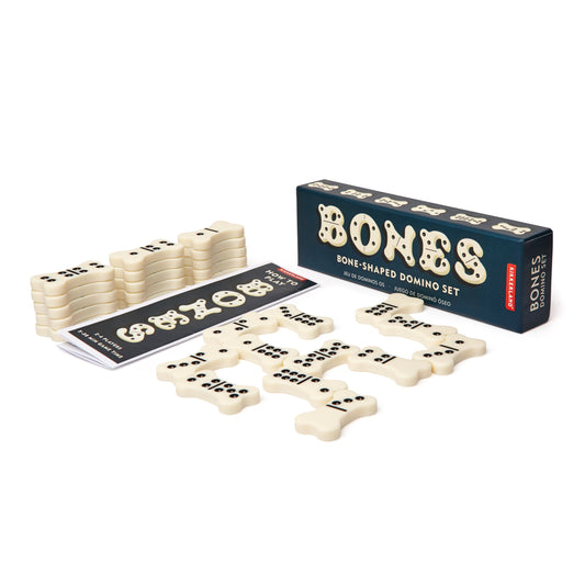 image shows a box with the word Bones printed on the top. the contents of which are dominoes , in the shape of cream bones with black spots. these are shown in front of the box in small stacks