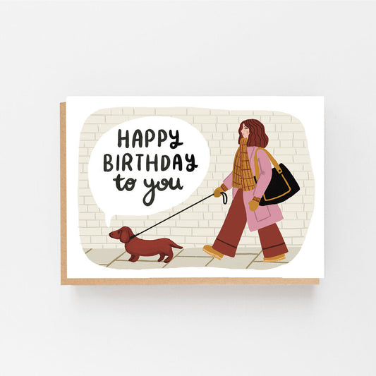 Happy Birthday to you are written on the front along with a picture of a lady walking a dachshund.