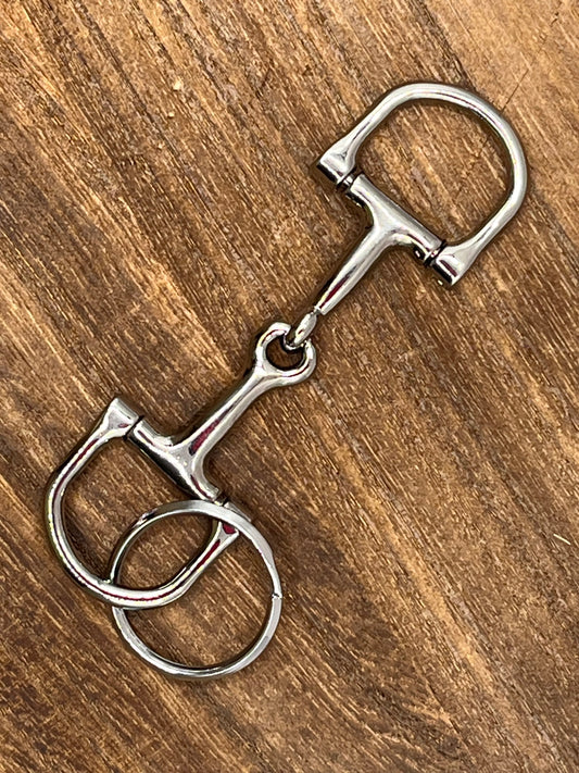 Metal horse bridle bit keyring  on a wooden surface