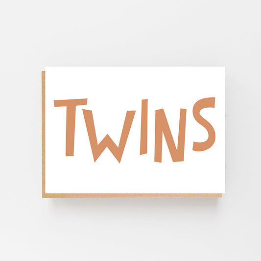 Greeting card in Landscape with the word TWINS on the front in gold writing. White Background. Brown Kraft Envelope.