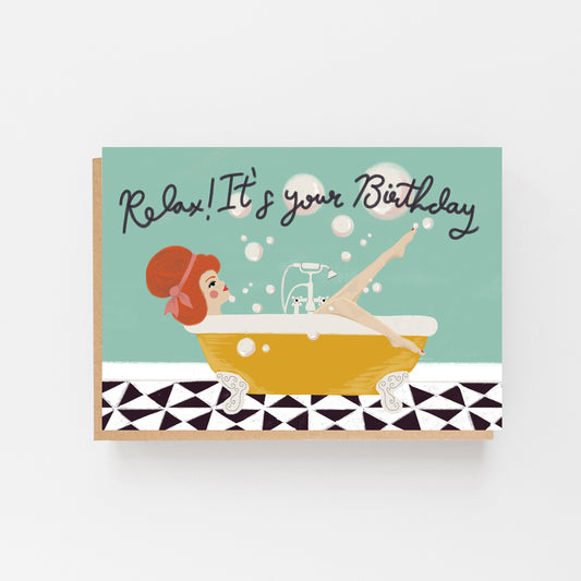 Greeting Card in landscape with a pale blue background with the words Relax ! It's Your birthday in black. There s a picture of a lady in a bath with white bubbles above the bath which is yellow in colour and a black and white tiles below the bath. Brow Kraft Envelope.