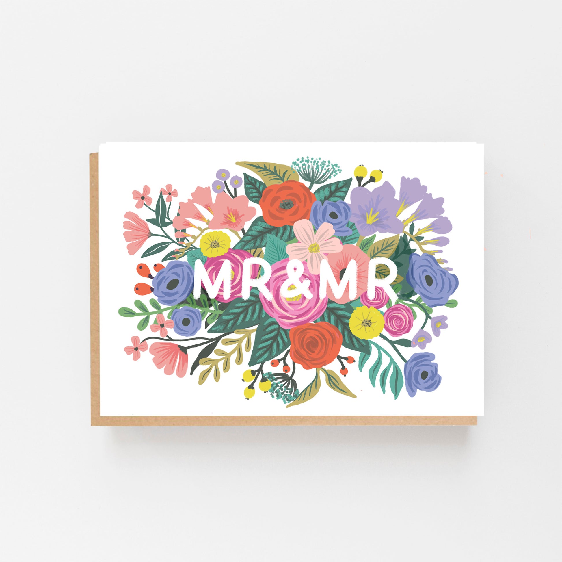 Wedding Card with the words MR & MRS in white in the middle of the card which is displayed landscaped . the words are surrounded by multi coloured flowers. Brown Kraft envelope.
