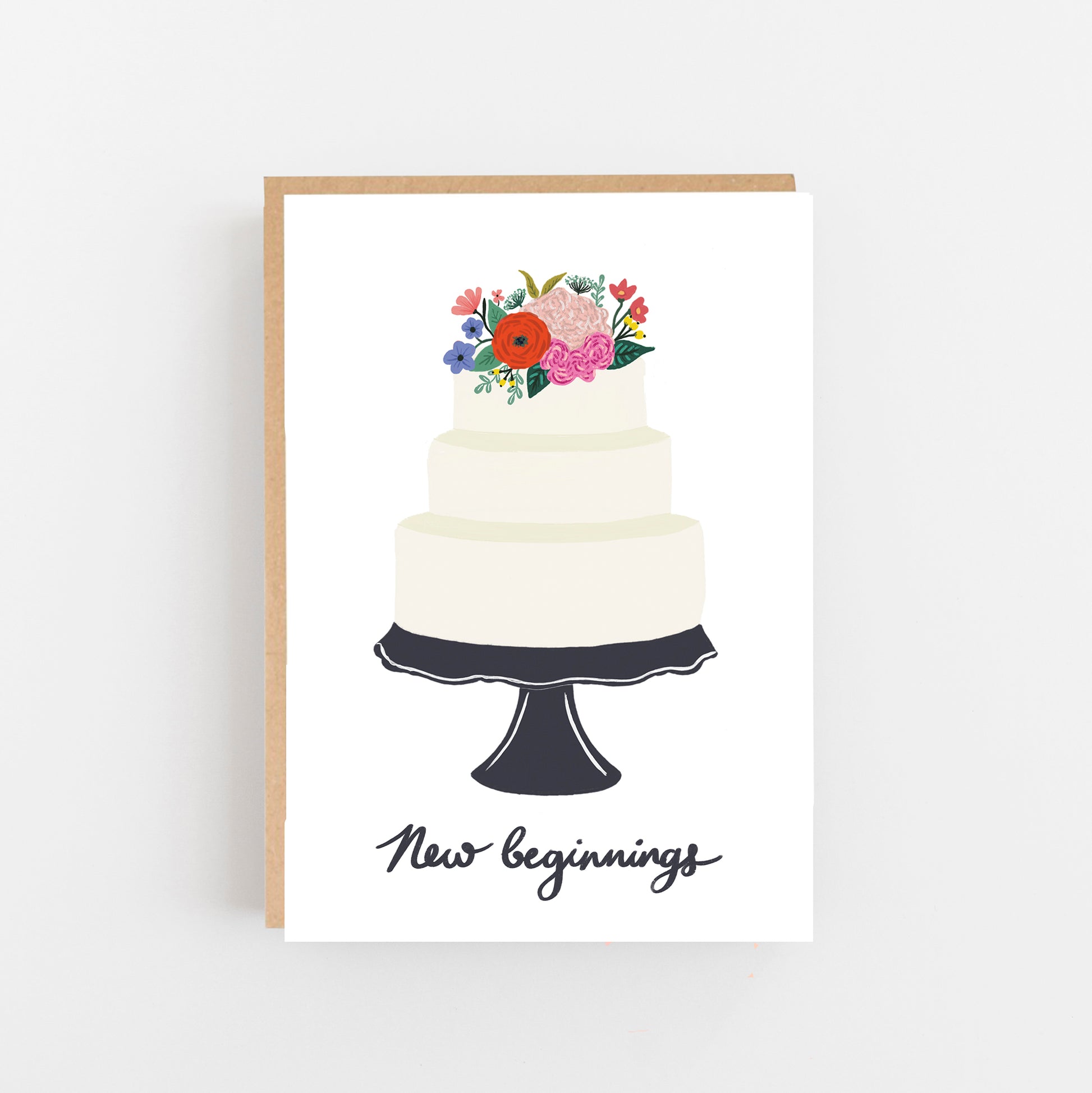 Wedding Card white background with a cake on a black cake stand bunch of flowers on top of the cake underneath the cake stand the words new beginnings in Black. Brown Kraft envelope.
