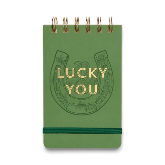 Green notebook with a horseshoe design and 'Lucky You' text on a white background