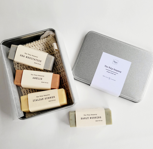 silver metal box which is opened and inside are 4 rectangular bars of soap , each a different colours and scents.