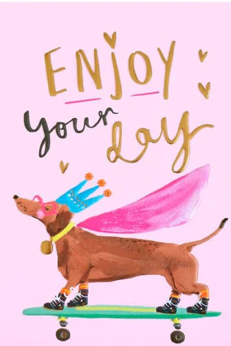 Card with a dachshund on a skateboard and 'Enjoy your day' text on a pink background