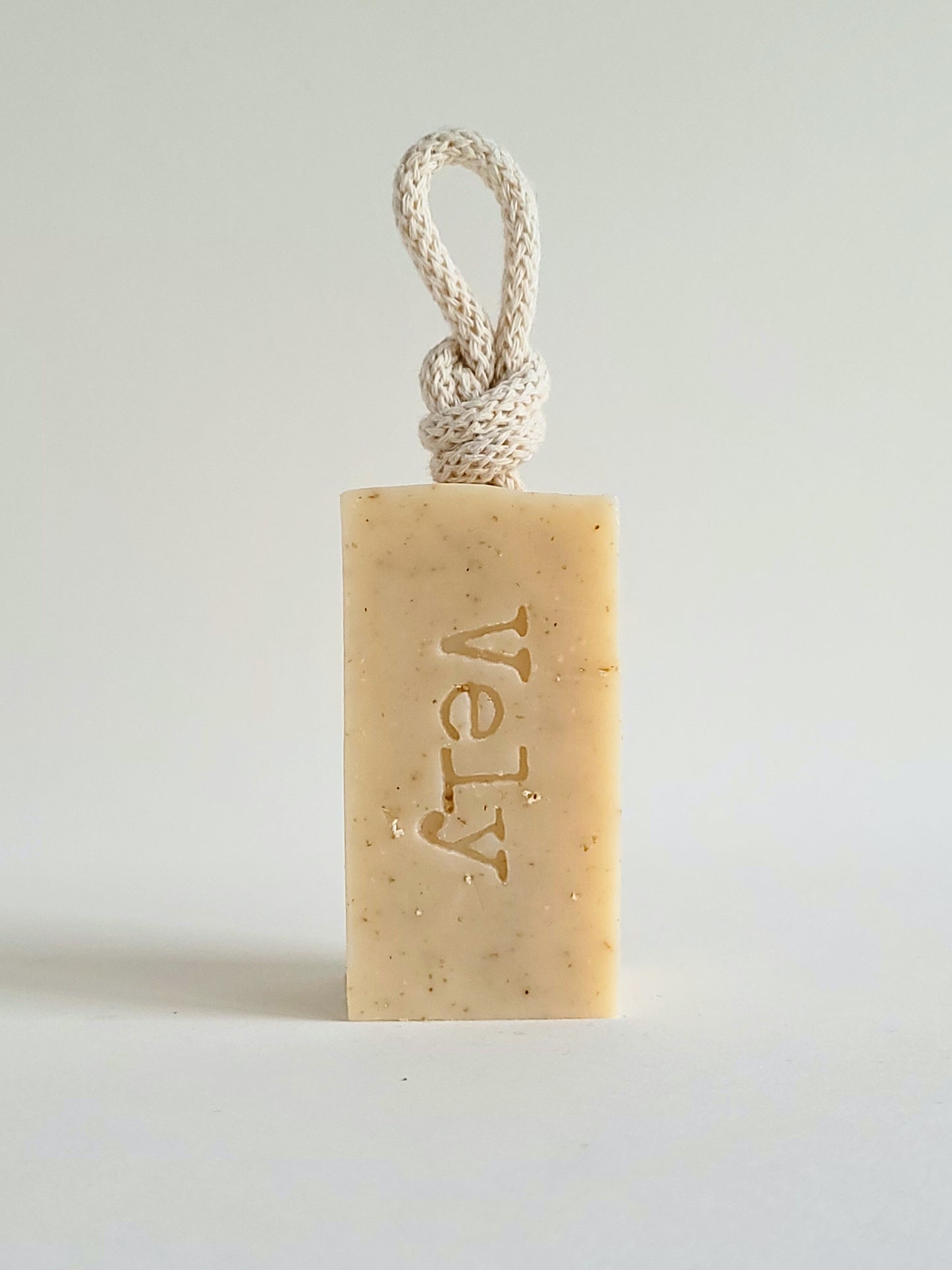 cream soap with cream rope . The word Vely is etched into the soap