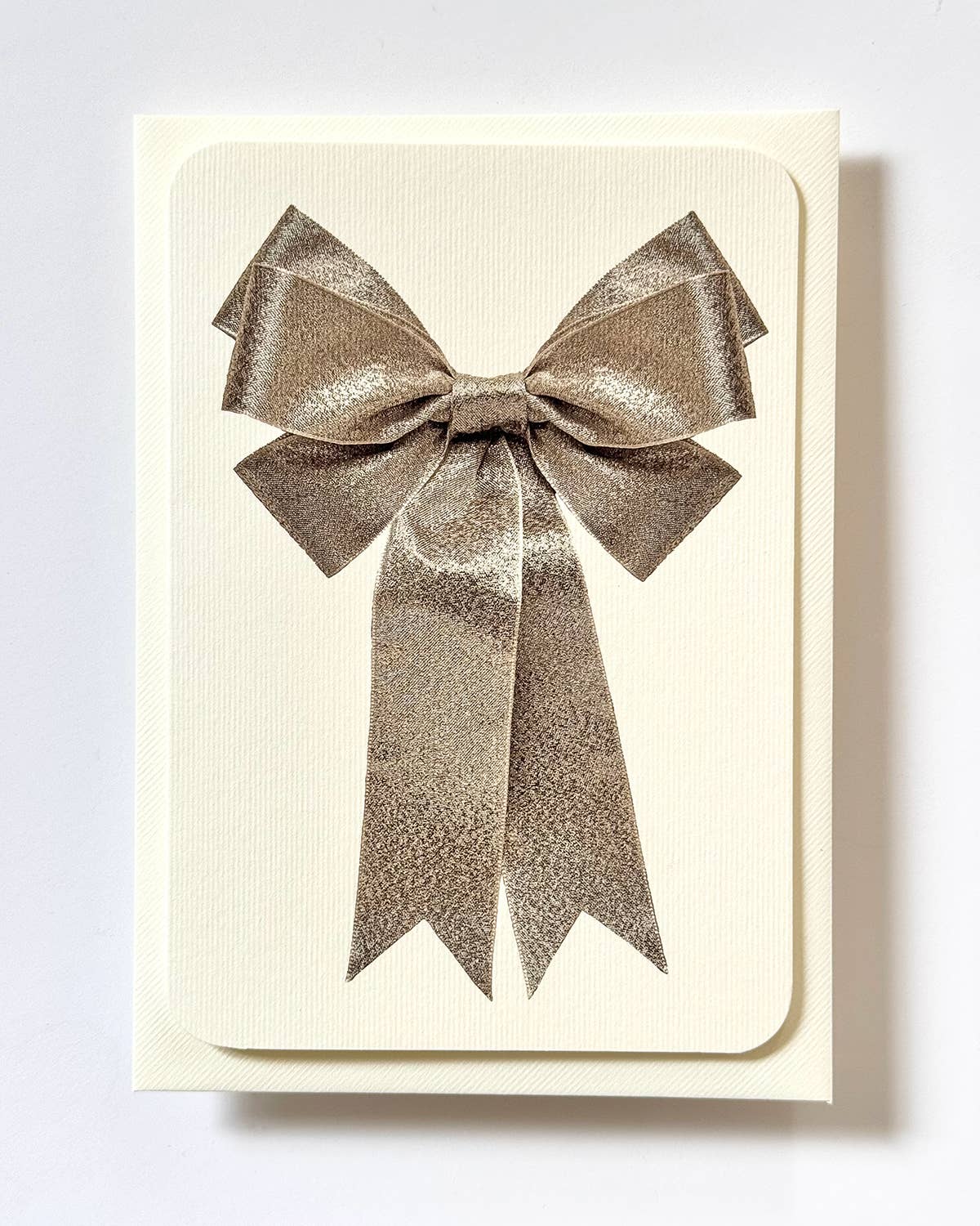 Greetings Card with a Silver Ribbon looking bow on the front. Looks like real material but it is an image  White Background.  White Envelope.