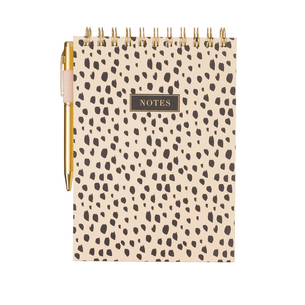 Notebook with dalmatian print cover and gold pen on a white background