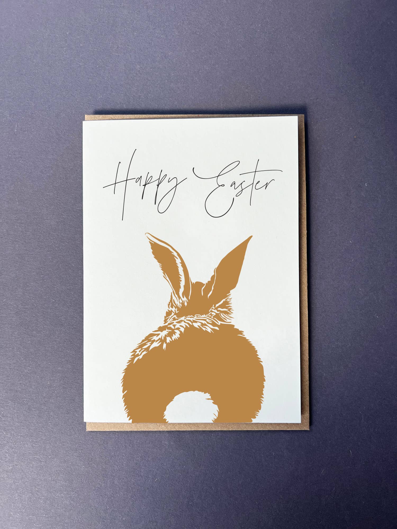 Greeting card with gold bunny silhouette and 'Happy Easter' text on a white background