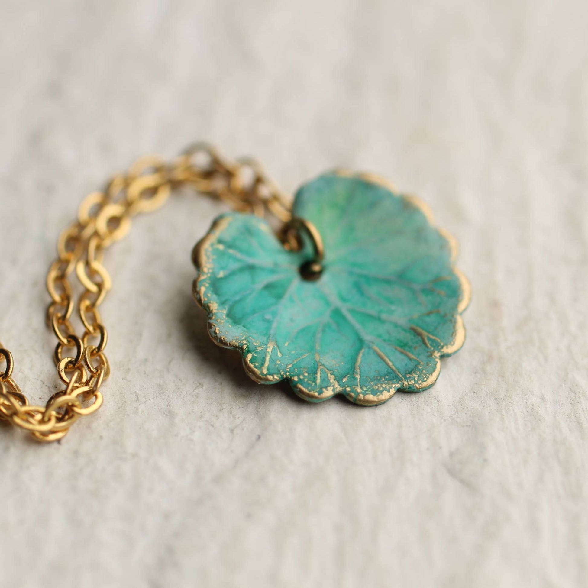 close up image of the turquoise leaf necklace with gold chain