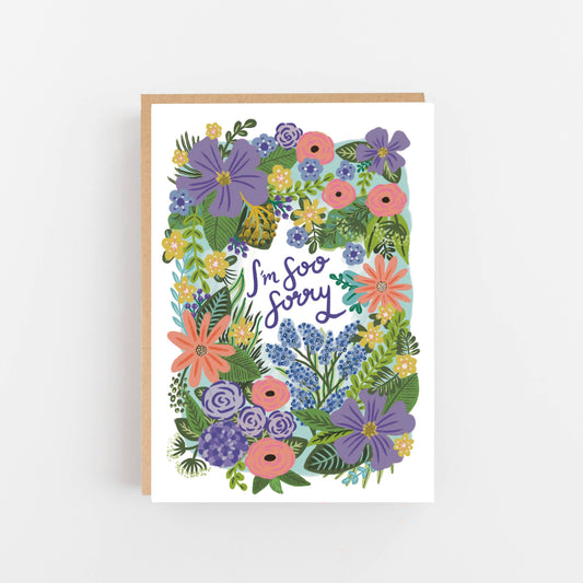 greeting card with a floral decoration of pink, red, purple flowers and green leaves. Written in the centre  it states Im soo sorry. The card is blank inside for your own message and comes with a kraft envelope