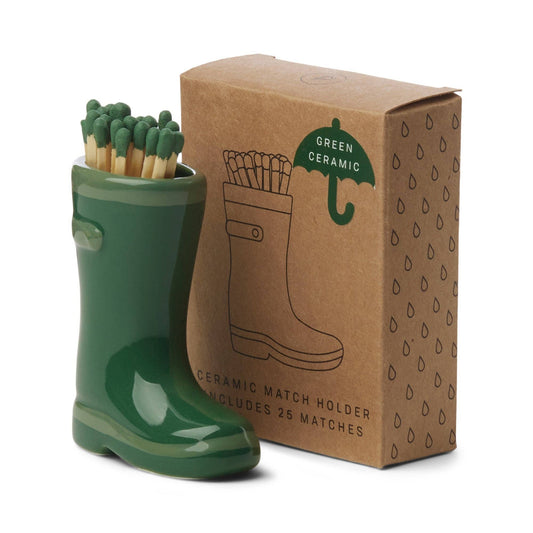 image shows a small green ceramic holder in the shape of a wellington boot. in the opening of the wellington boot are 25 matches with green tips