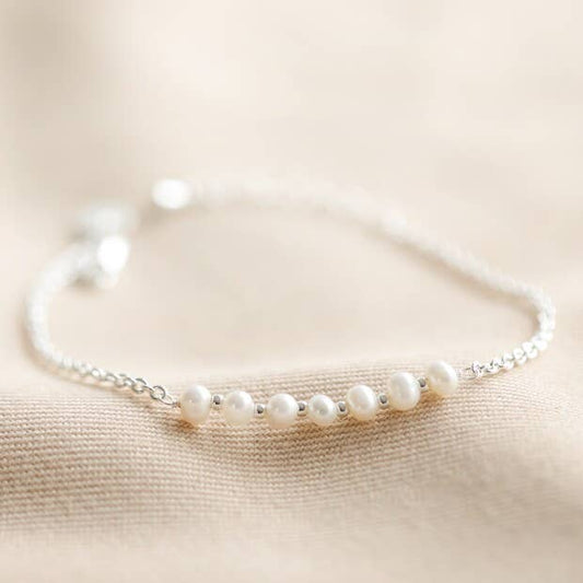 Pearl bracelet on a beige fabric background