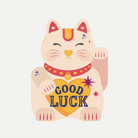 Decorative cat figurine with 'Good Luck' heart on a light gray background